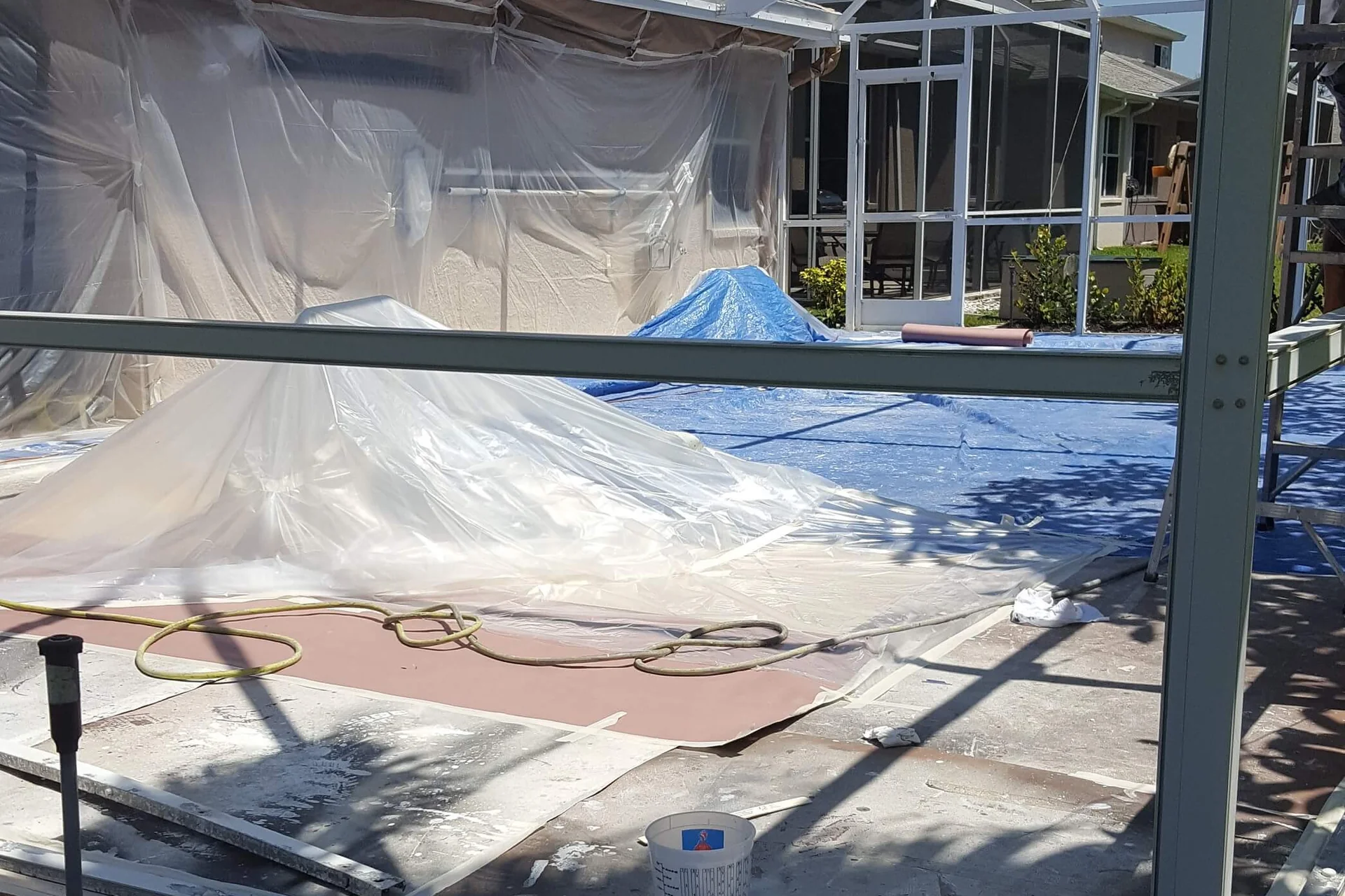 Professional pool cage surface preparation with pressure washing and sanding before DTM coating application in Tampa Bay