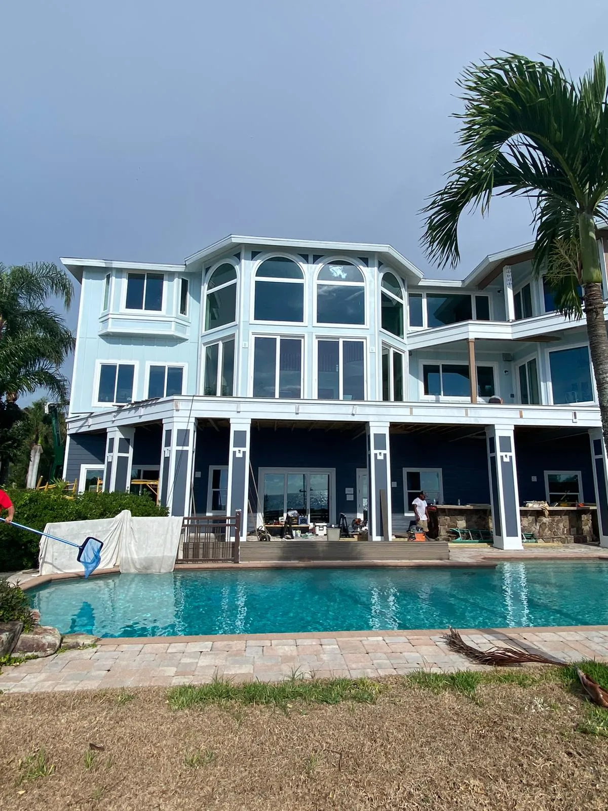 Large coastal home rear elevation repainted, with pool and lanai