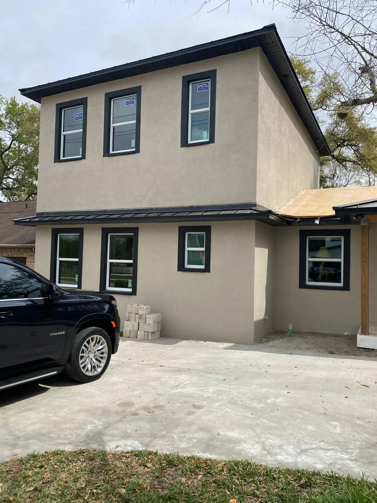 Modern two-story gray stucco home with black-trimmed windows