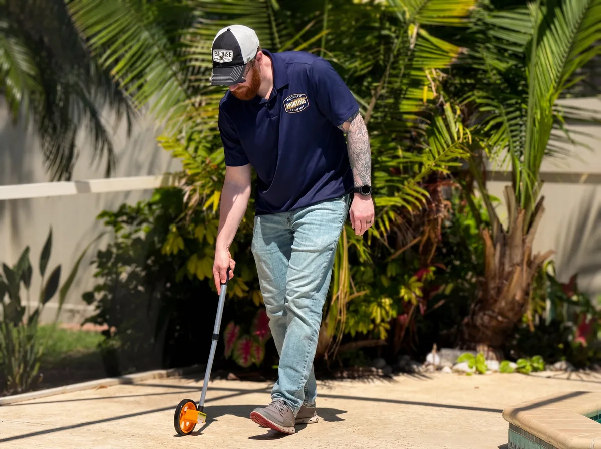 John Tortorich measuring a Tampa Bay pool deck before a refinish project